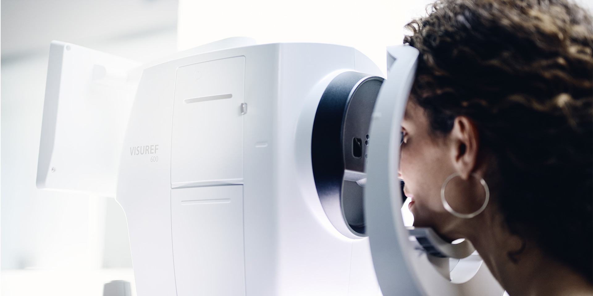 En kvinna tittar genom ZEISS VISUREF 600
