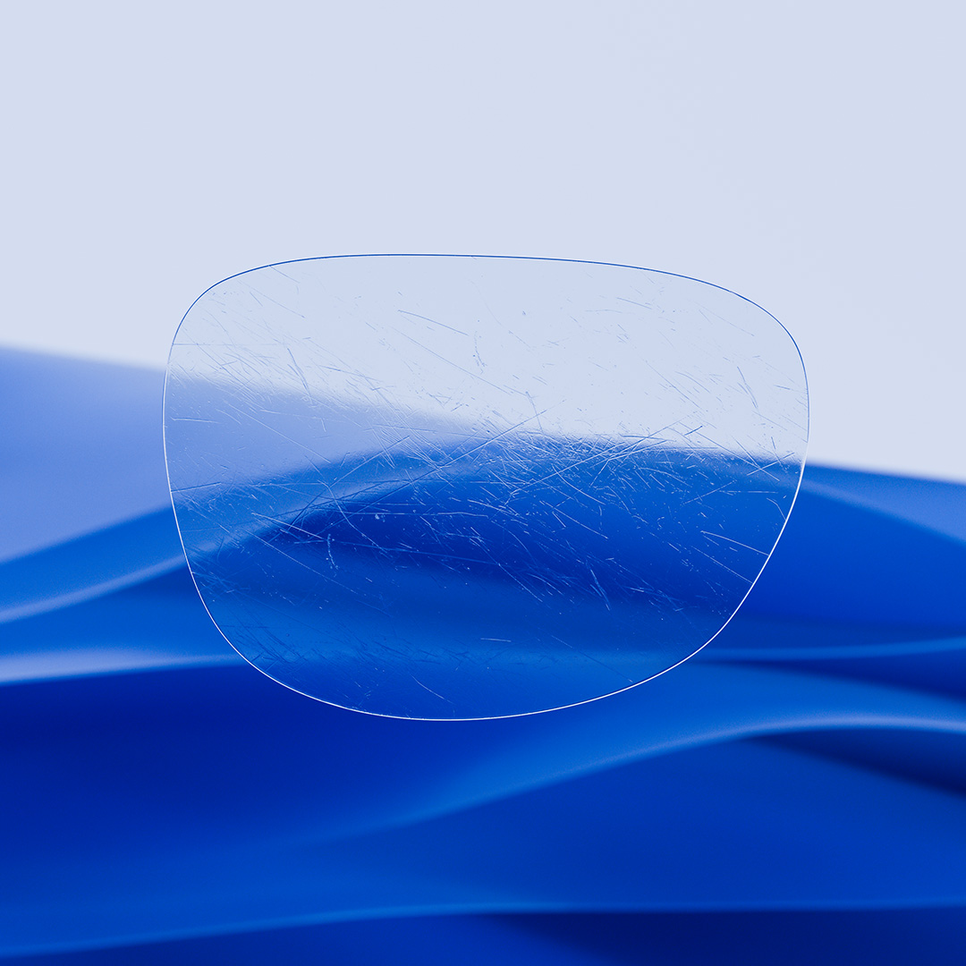 Ett delat glasögonglas där ena sidan, med ZEISS DuraVision, är klar och ren, och den andra sidan av glaset är täckt av repor.