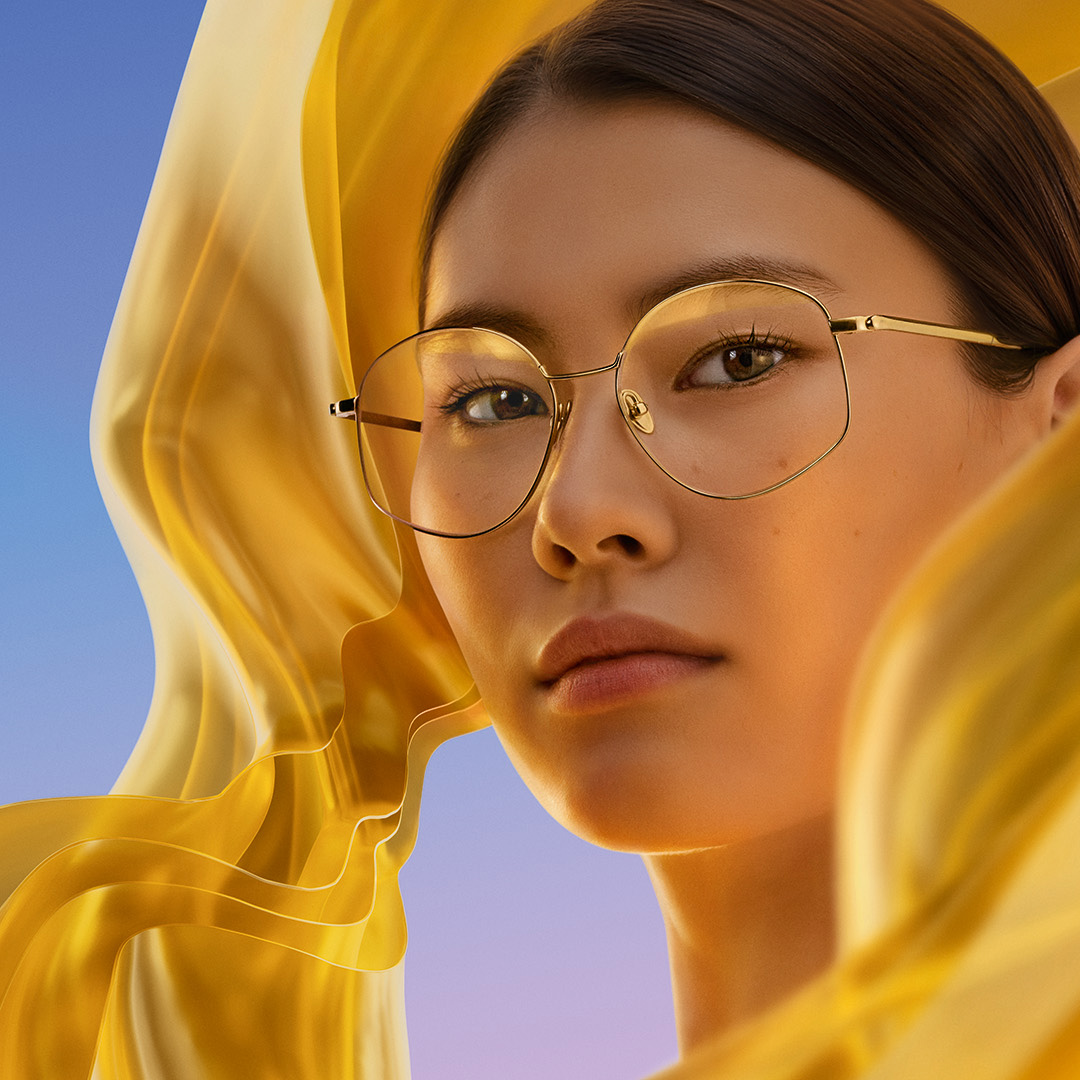 En kvinna bär glas med ZEISS DuraVision Gold UV antireflexbehandling, som visar den diskreta guldfärgade reflexen på glaset.