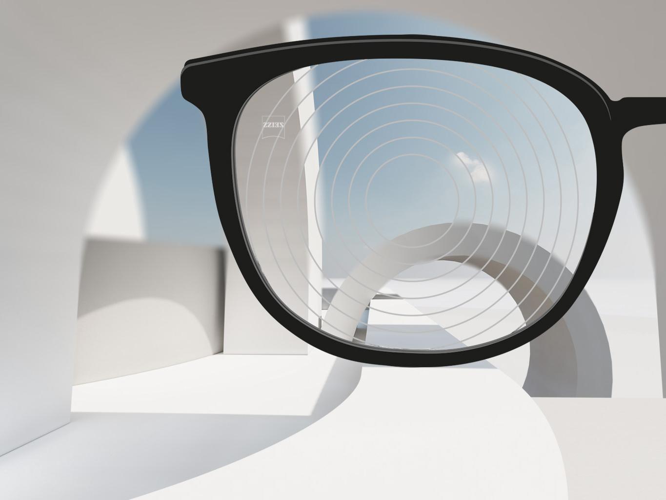 En närbild av glas för myopihantering från ZEISS, med svarta glasögonbågar och koncentriska cirklar på glasytan. 