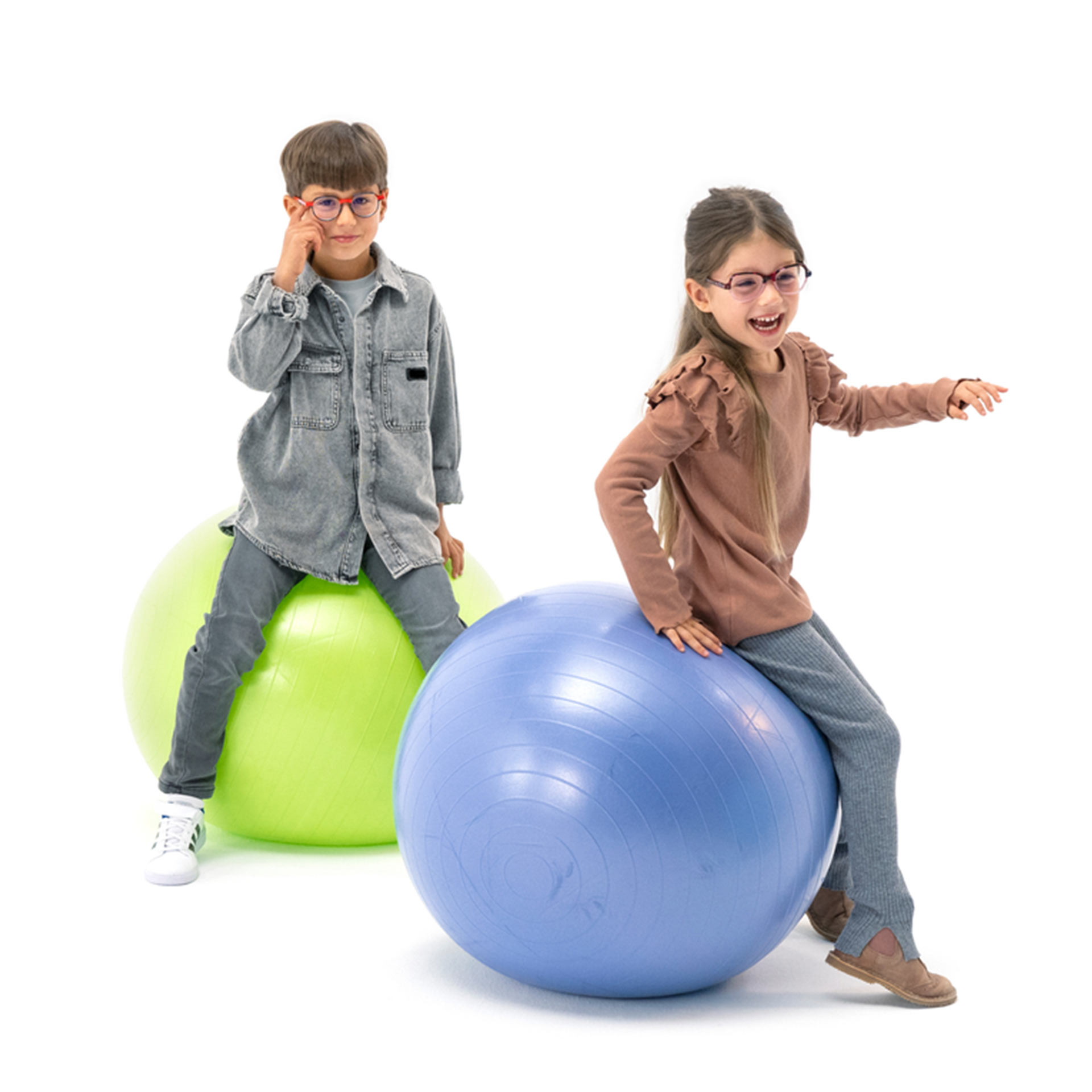 En pojke och en flicka som båda bär glasögon, studsar bollar.
