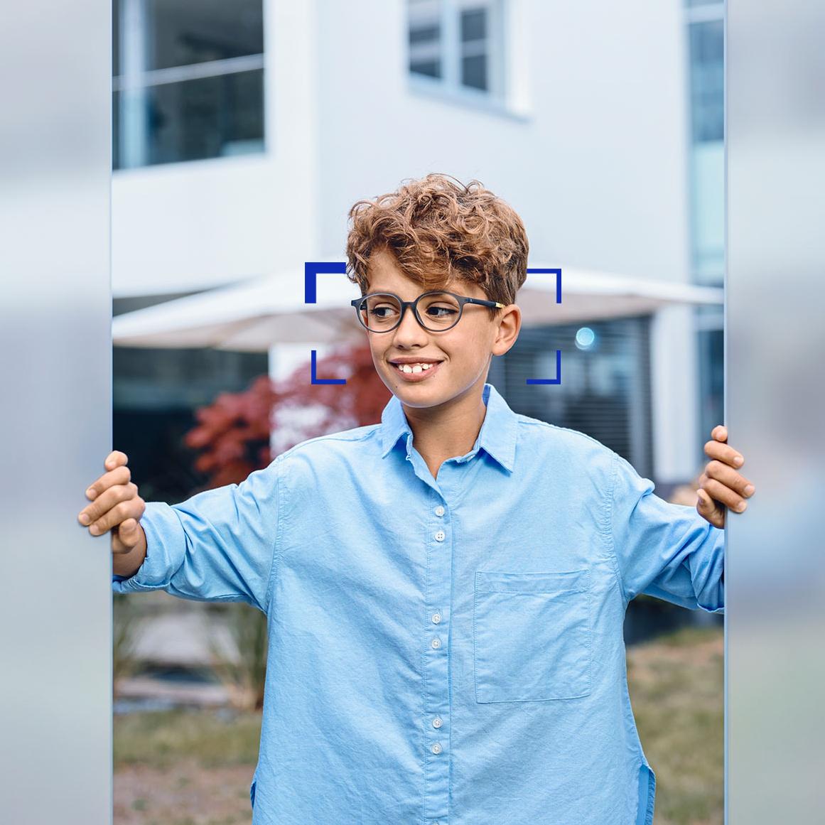 En ung pojke som bär ZEISS SmartLife Young glasögonglas