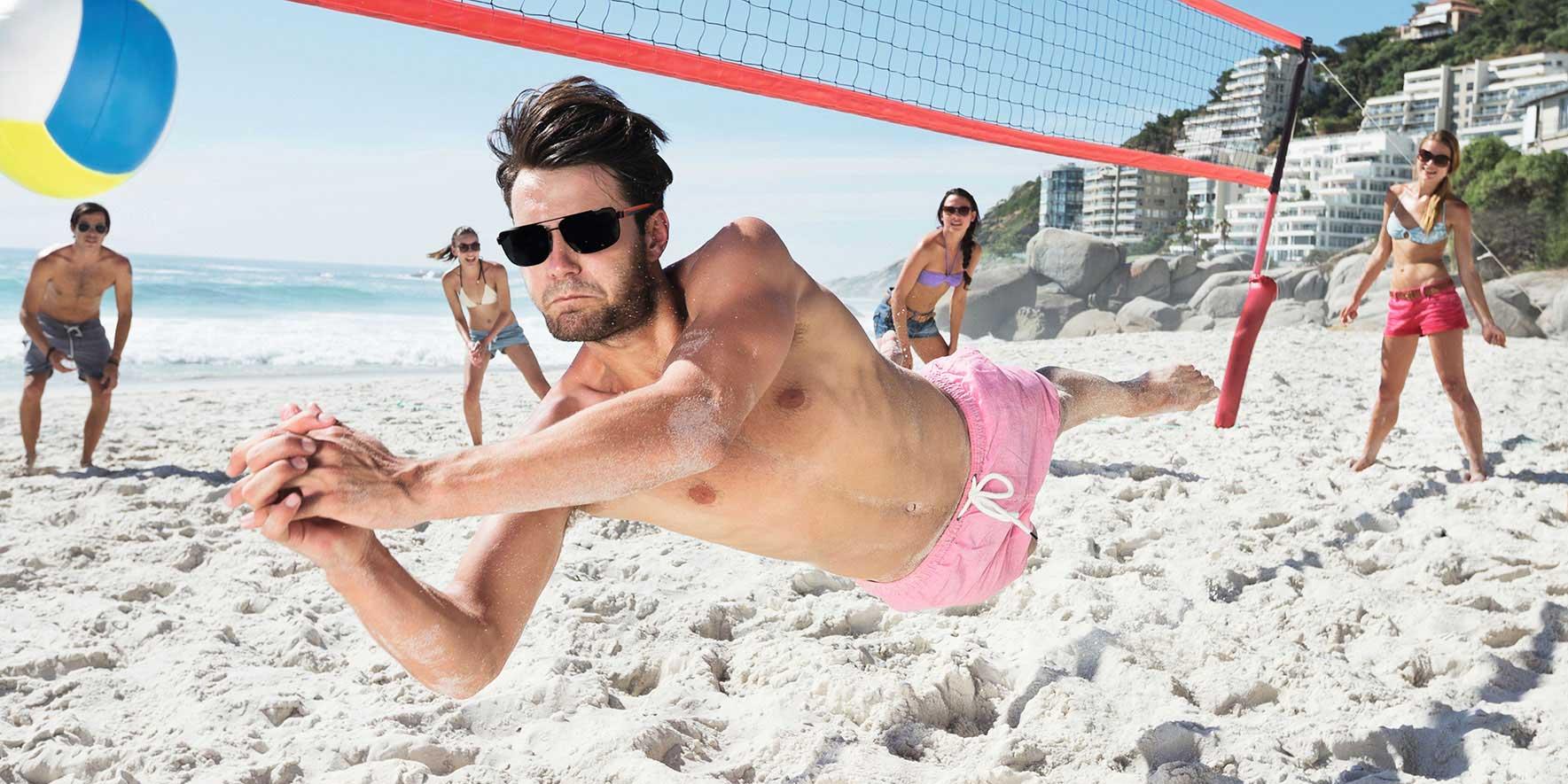 Personer som spelar beachvolleyboll på stranden