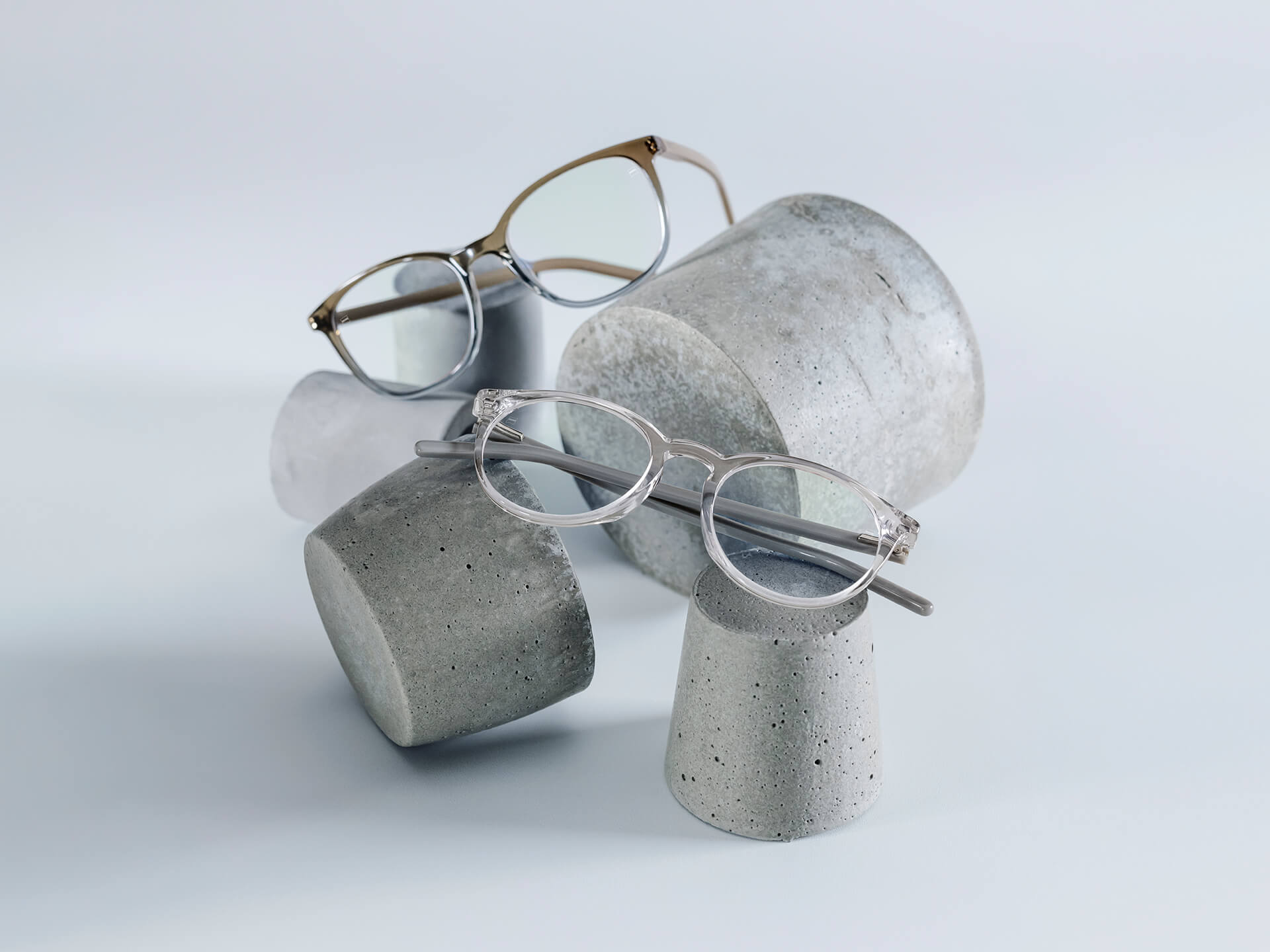 Glasögon med ZEISS-glas försedda med DuraVision® Chrome-ytbehandling ligger på stenunderlägg av olika storlek.