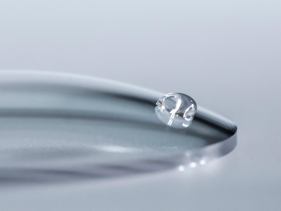 En vattendroppe pärlar av ett ZEISS-glas med Easy Clean-ytbehandling.