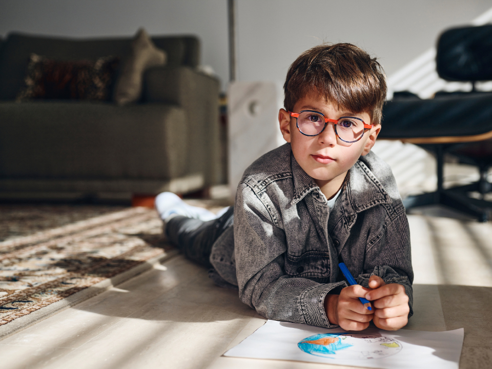 En ung pojke med ZEISS MyoCare-glas tittar rakt in i kameran.