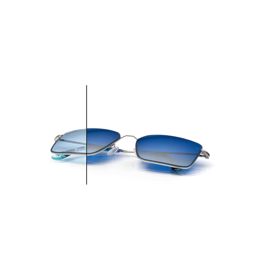 Glasögon med ZEISS PhotoFusion X-glas i blått med ZEISS DuraVision Flash spegelbehandling i färg Diamond. Hälften av glaset har inte mörknat helt, för att visa skillnaden i färg.