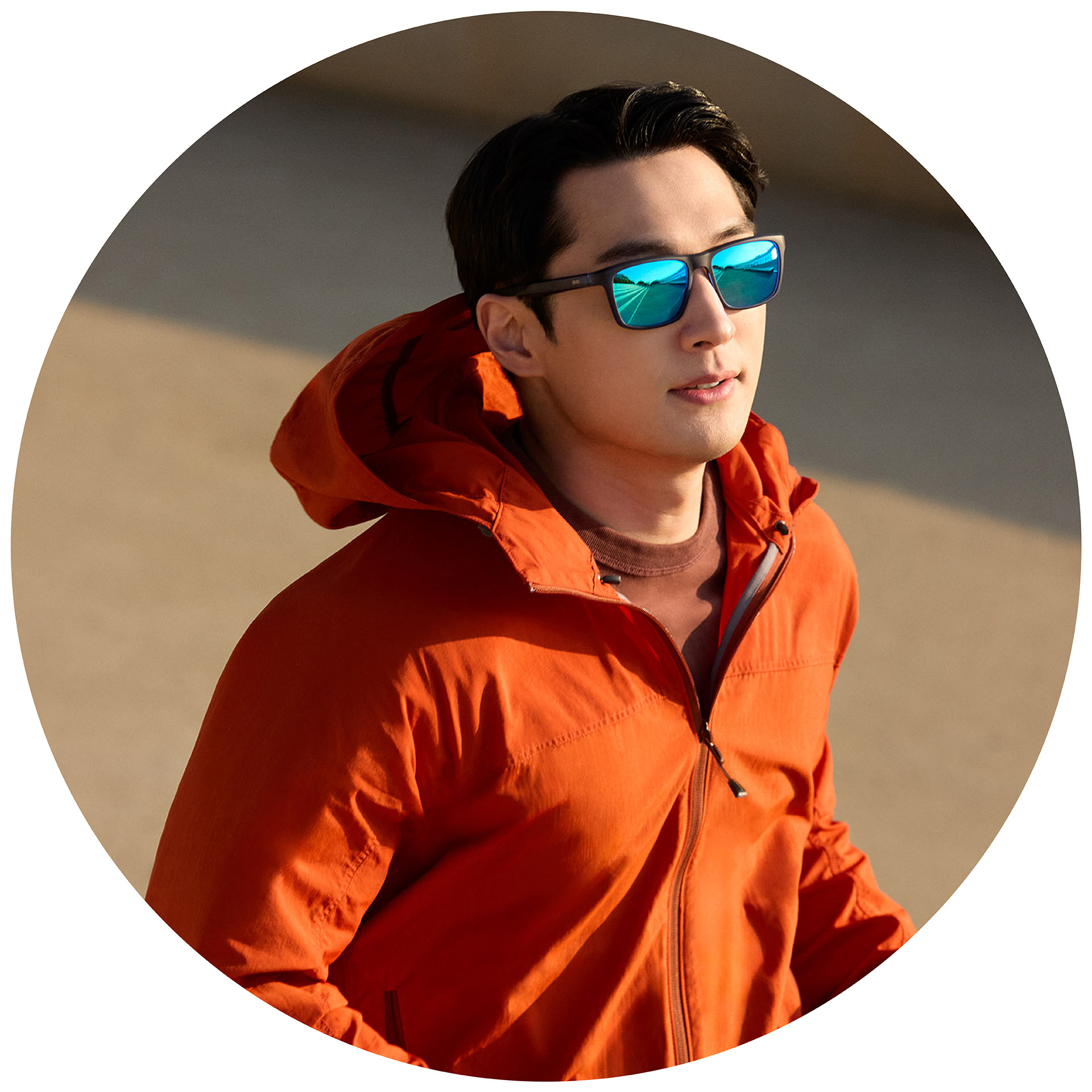 En joggare med orange jacka bär ZEISS solglasögon med styrka och en ytbehandling i blått.