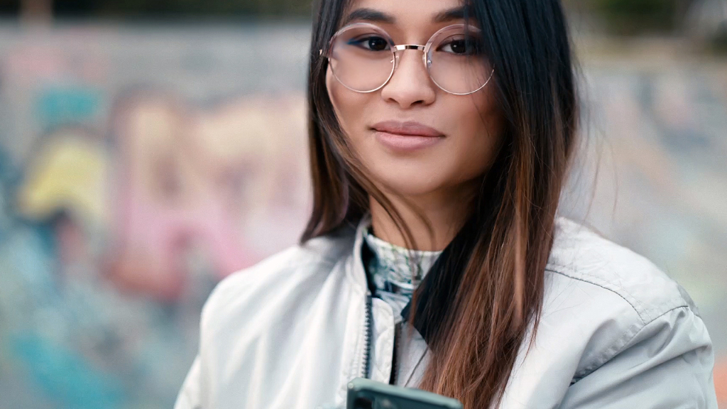 En ung kvinna i en skatepark som bär ZEISS SmartLife enstyrkeglas.