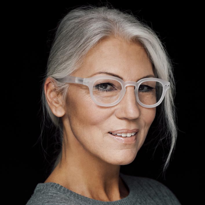 Kvinna med grått hår och vita bågar med ZEISS SmartLife progressiva glas. Geometrisk ansiktsskanning som visar mätningar av ansiktsanatomin och bågen.
